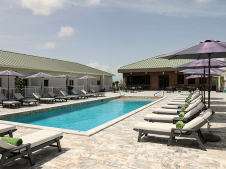 pool with lounge chairs and restaurant in background