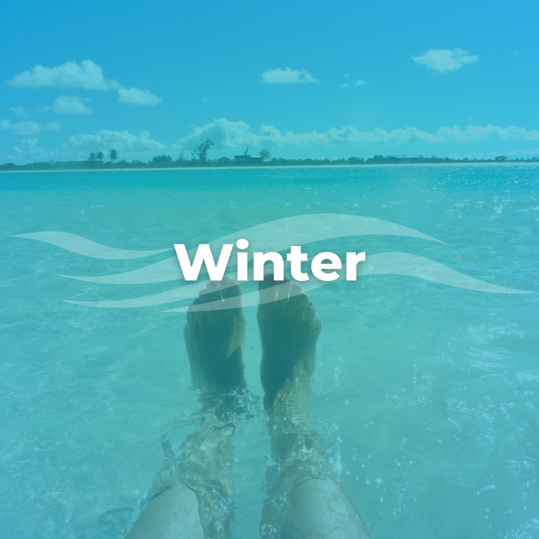 Person's legs resting in the water in Caicos