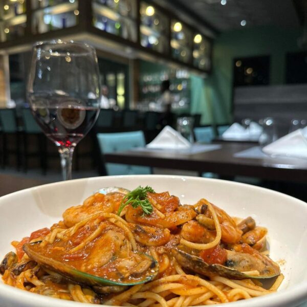 food on a plate with a glass of wine